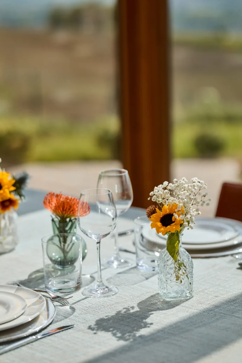 Tavola apparecchiata con vasetti di fiori